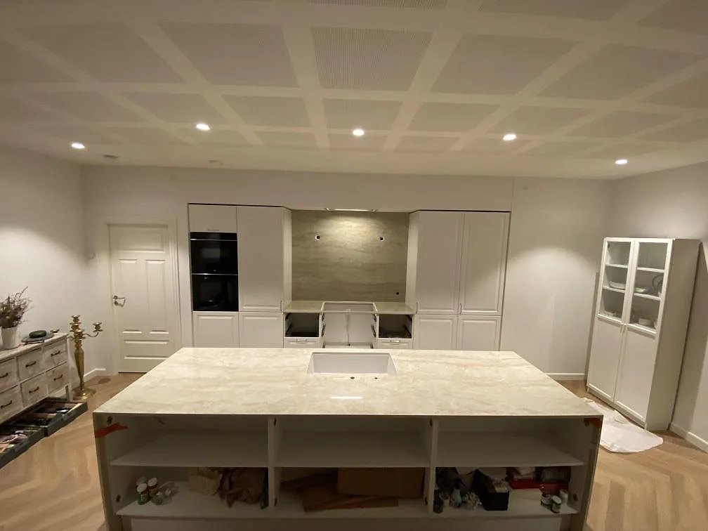 Köksö och bänkskivor i polerad Dekton Arga, keramisk sten, med matchande väggbeklädnad i ett kök i Hornslet.
