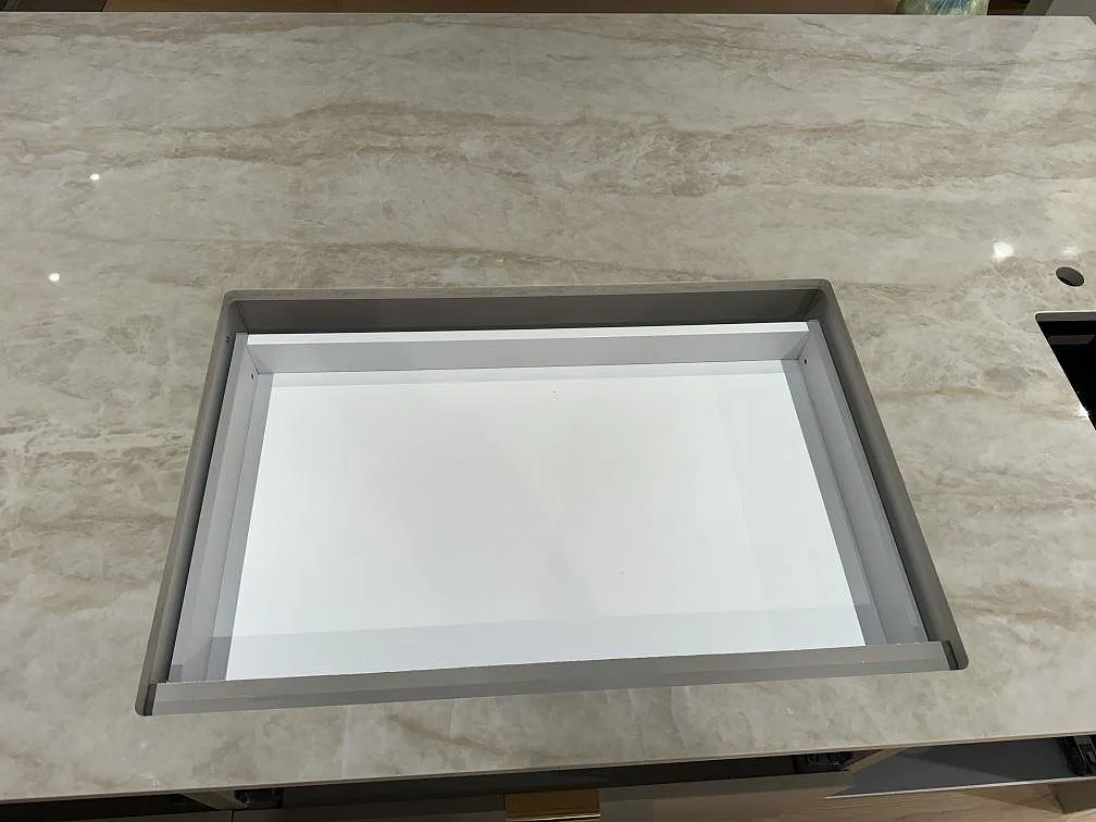 Detalj av diskhoöppning i polerad Dekton Arga med varm ljus ådring i ett kök i Hunnebostrand.