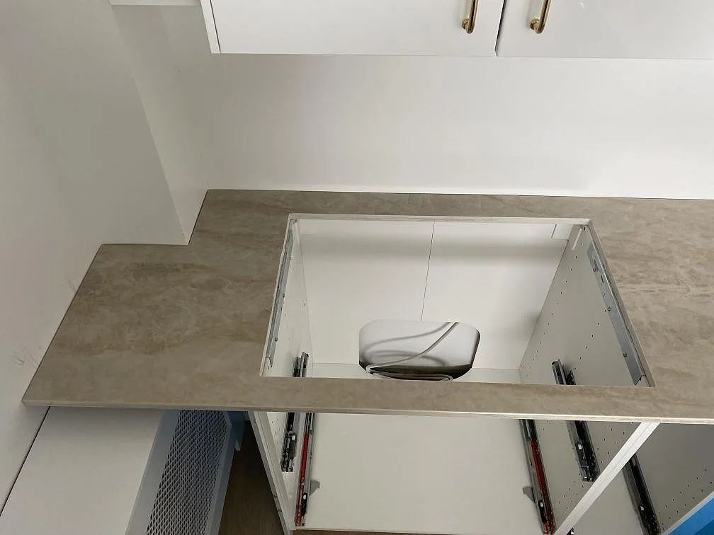 Rektangulärt hällurtag i en polerad Dekton Arga köksbänkskiva ovanför öppna köksstommar i Hvidovre.