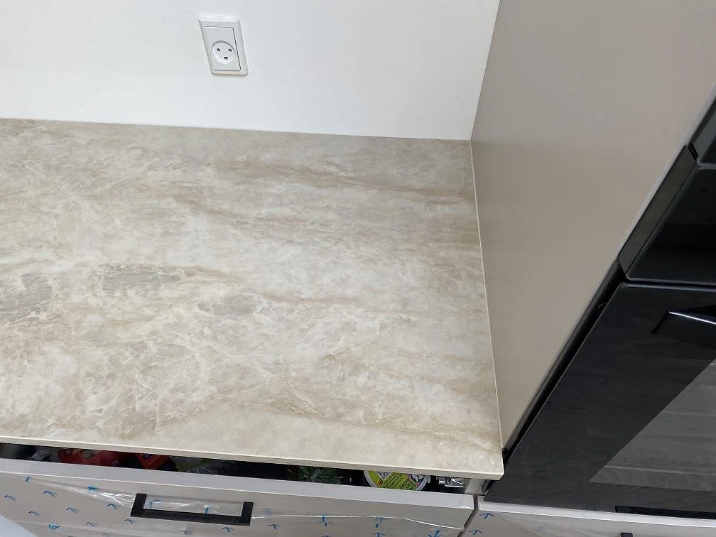 Avslut på polerad Dekton Arga mot högskåp, med ljus bänkyta och öppna köksstommar i Hvidovre.