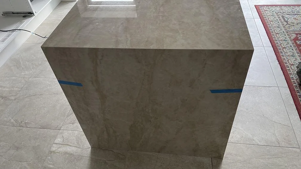 Gavelsida på köksö klädd i polerad Dekton Arga keramik med matchad ådring i Hvidovre.