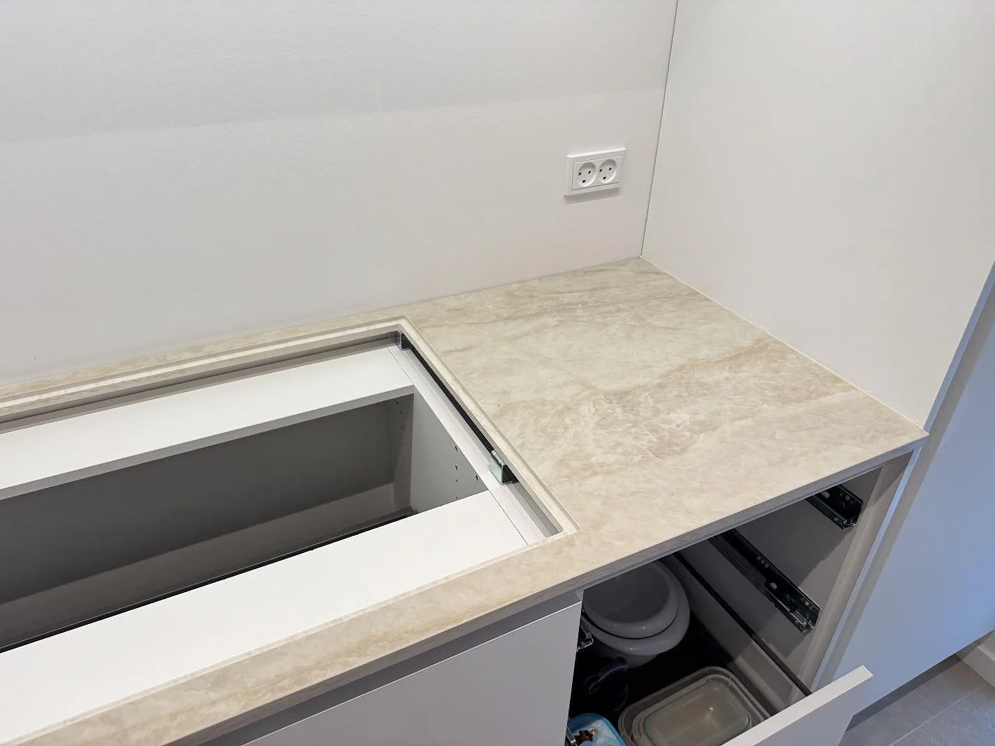 Polerad Dekton Arga längs väggbänk med rektangulär hällöppning och ljus vägg i ett kök i Hvidovre.