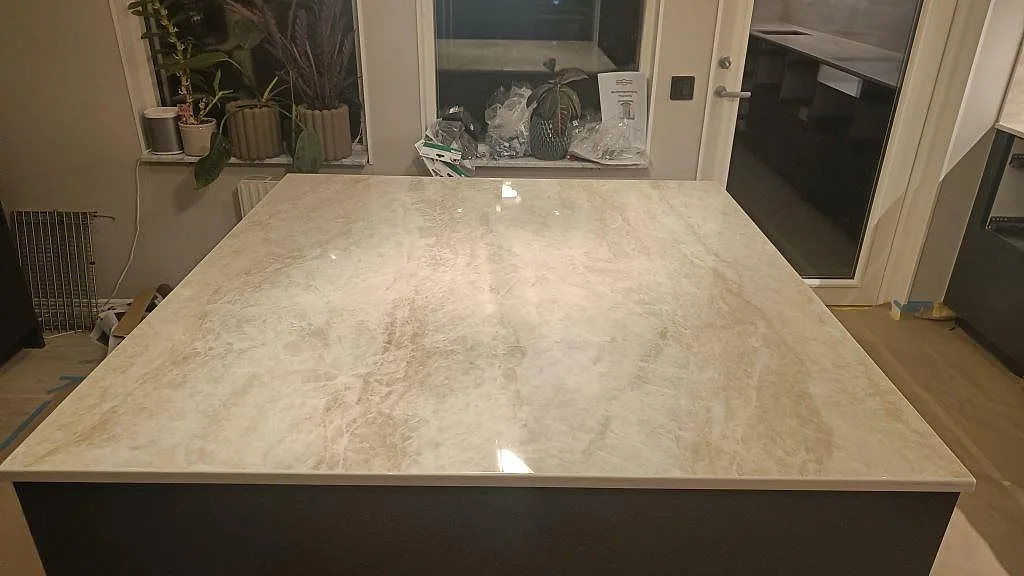 Köksö i polerad Dekton Arga ovanifrån, med mjuk grå ådring och blank yta i ett kök i Kalmar.