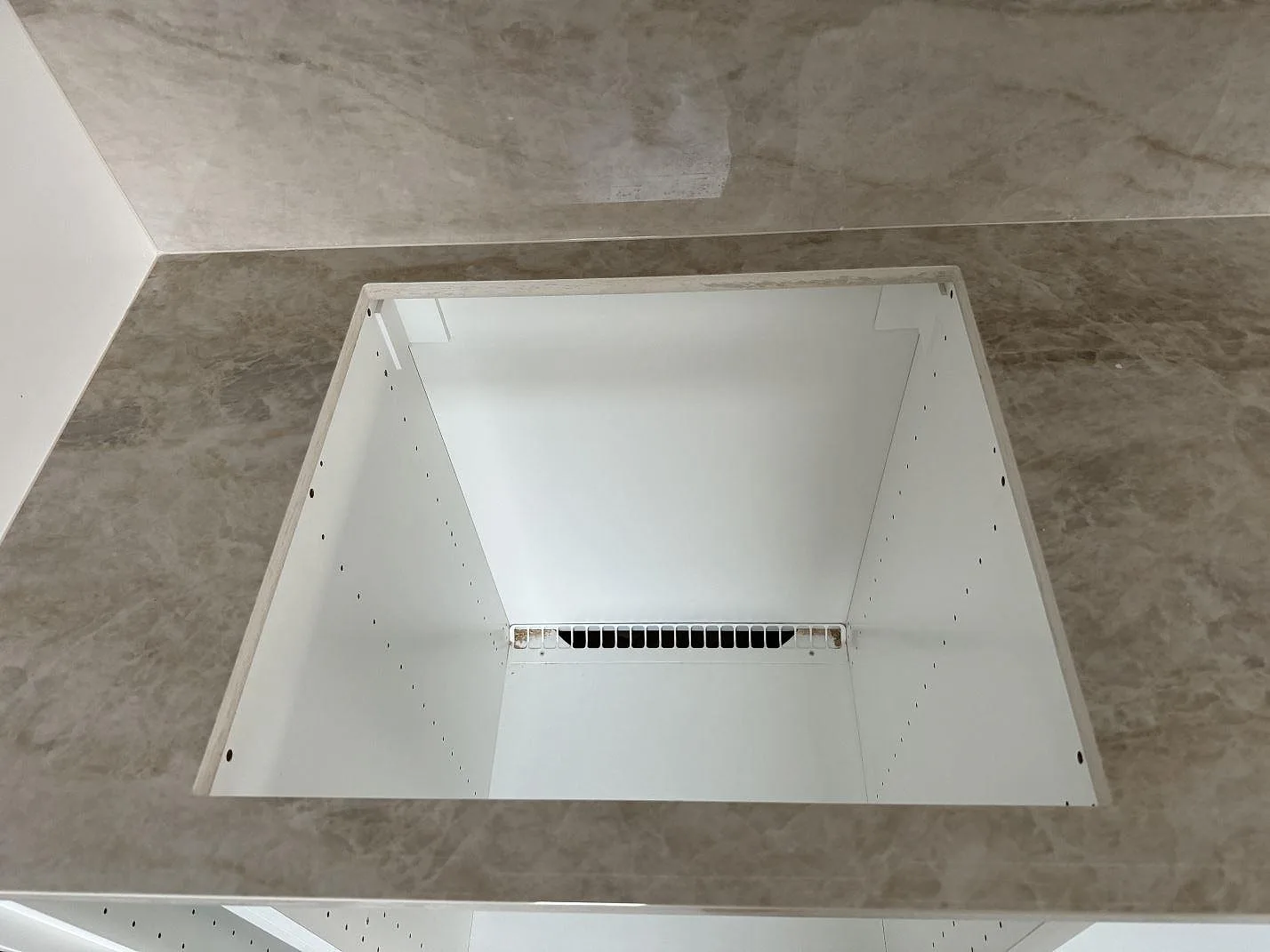 Närbild på polerad Dekton Arga runt öppen köksstomme med gråbeige ådring och väggbeklädnad i Kalmar.