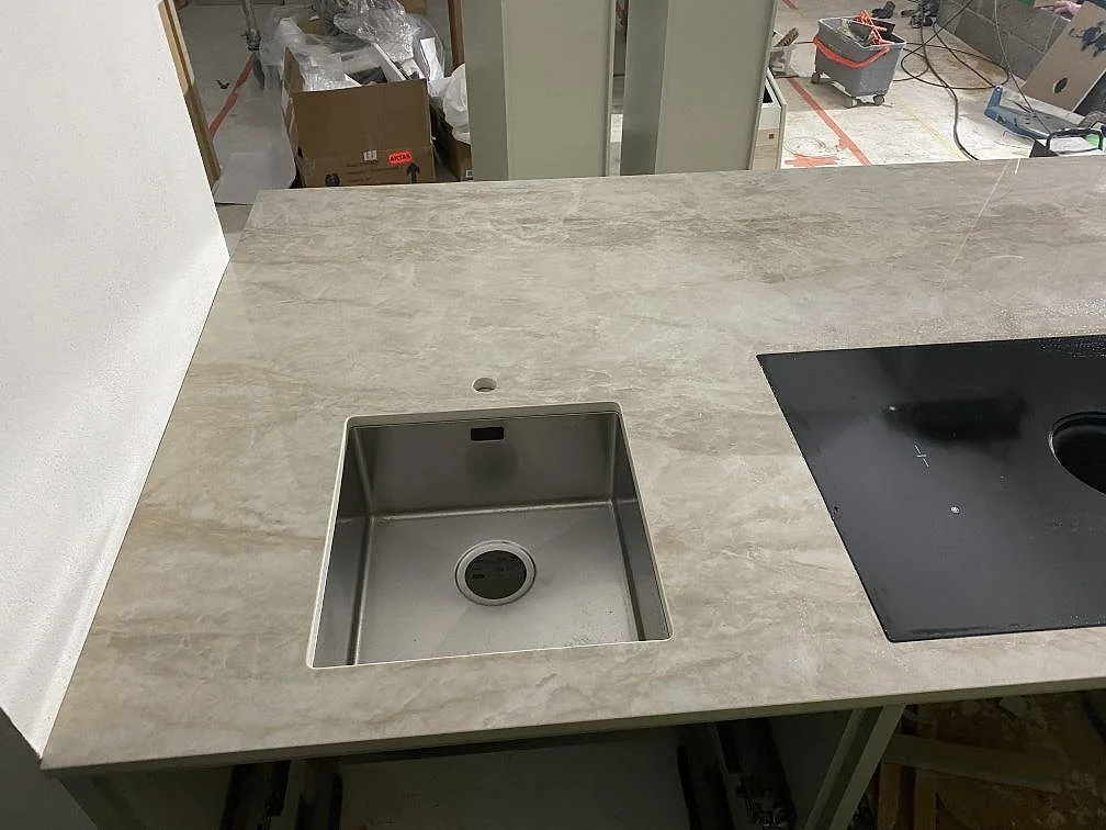 Polerad Dekton Arga som köksbänkskiva med rostfri diskho, svart häll och sammanhängande ådring i Kareby.