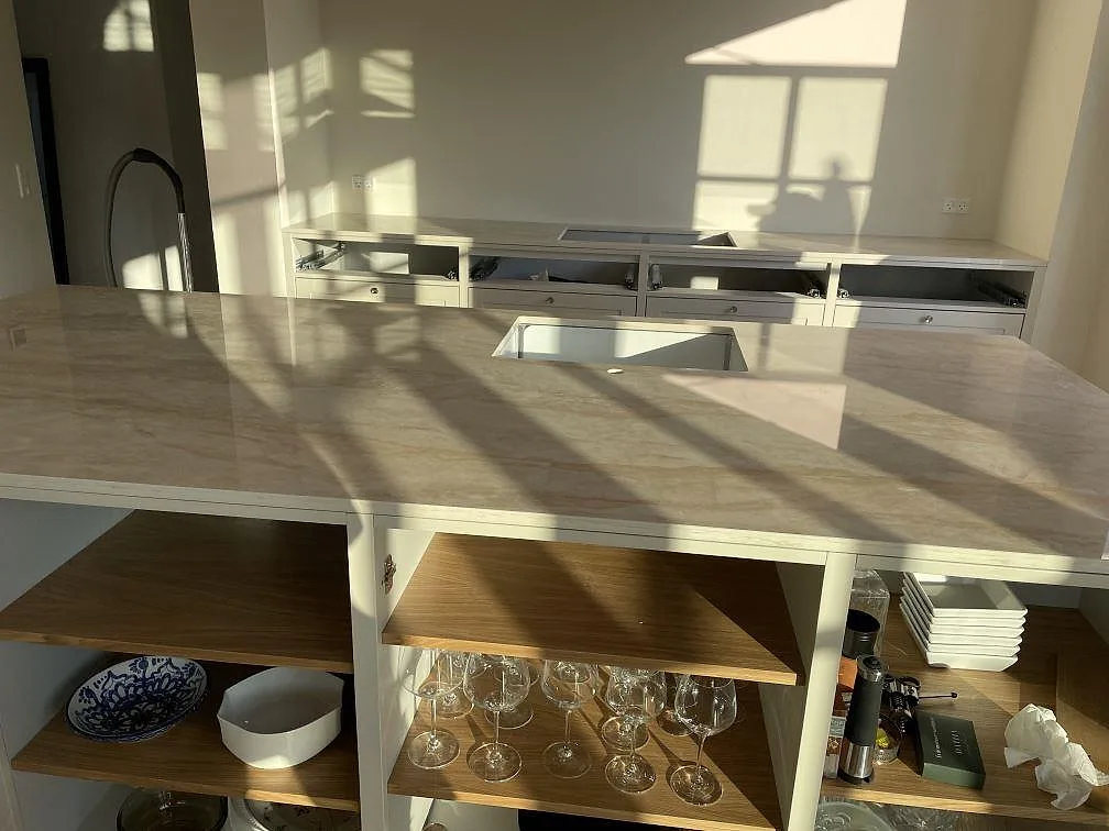 Polerad Dekton Arga som köksö med underlimmad diskho och bakre bänkrad i ett ljust kök i Kastrup.
