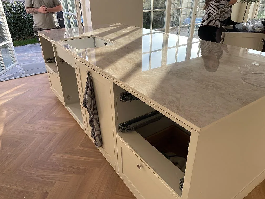 Blank Dekton Arga på stor köksö med synlig ådring, underlimmad diskho och stora fönster i Kastrup.