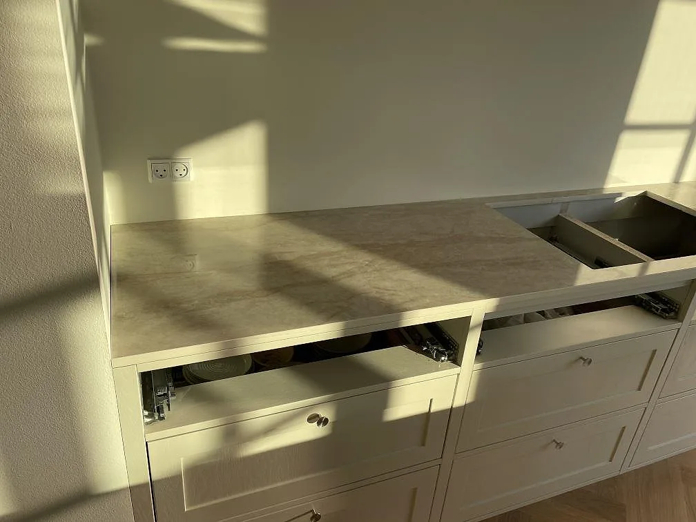 Detalj av väggbänk i polerad Dekton Arga med beige ådring och hällöppning i köket i Kastrup.