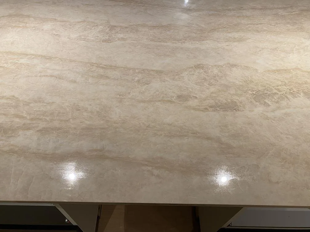 Närbild på den polerade ytan i Dekton Arga med beige ådring och spegelblanka reflexer, köksbänkskiva i Katrineholm.