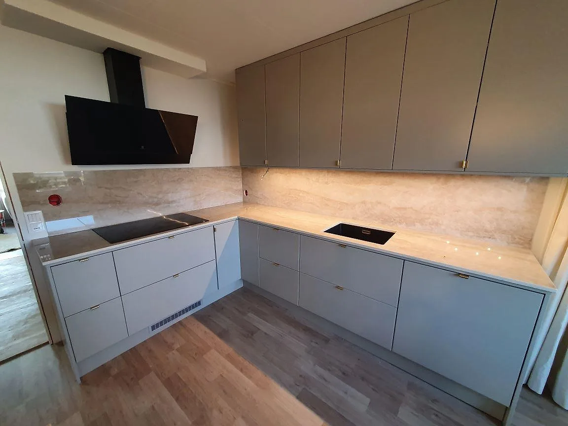 Köksbänkskiva i polerad Dekton Arga, 8 mm, med stänkskydd, häll och diskhodel i ett grått kök i Knutby.