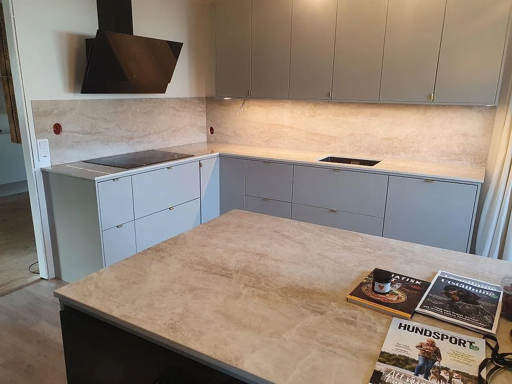 Polerad Dekton Arga som köksbänkskiva och köksö med ljus ådring och matchande stänkskydd i Knutby.
