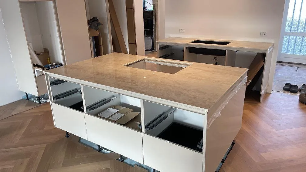 Köksbänkskiva i polerad Dekton Arga, keramik, på köksö och rak arbetsbänk i ett kök i Køge.