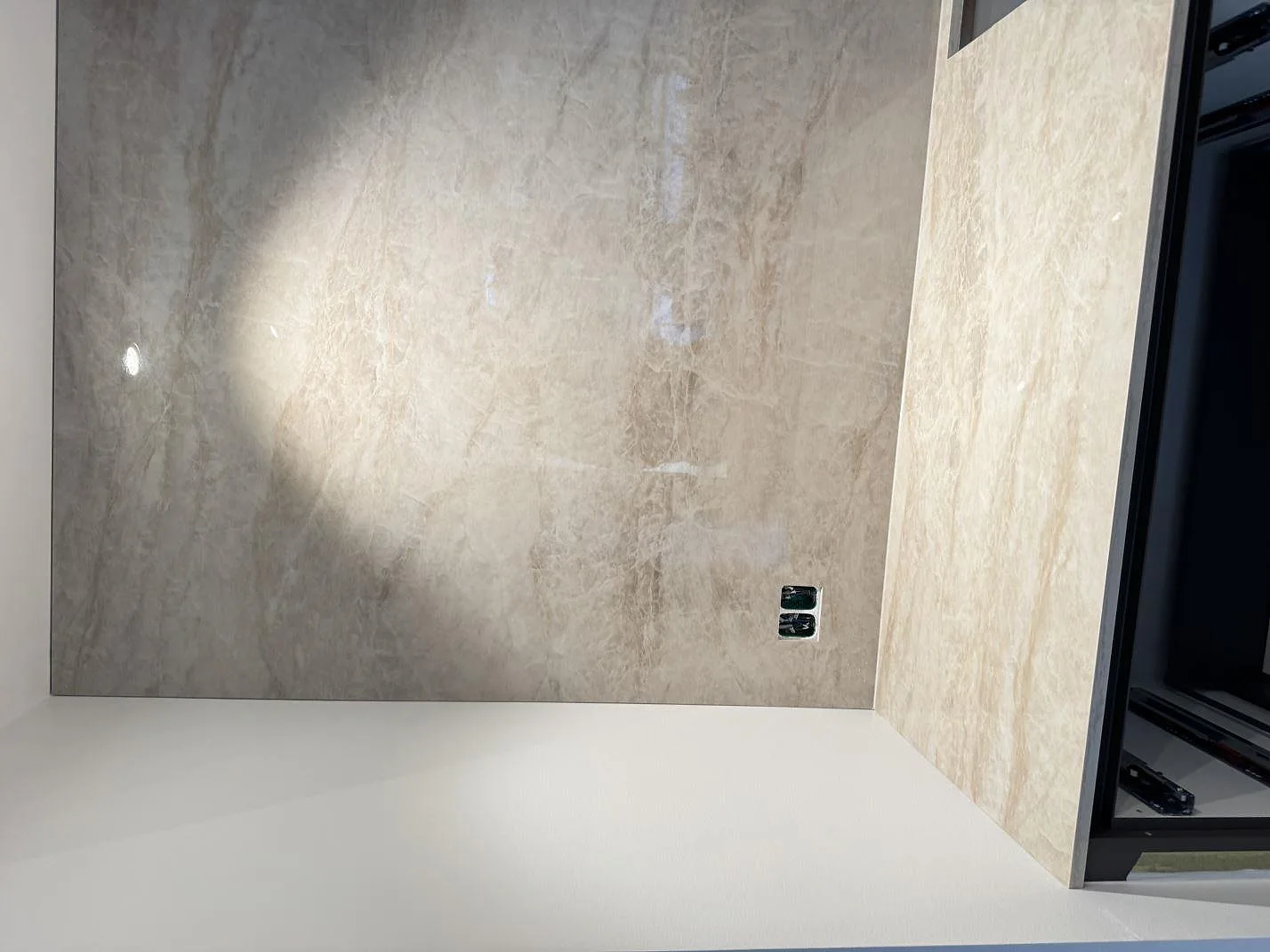 Väggbeklädnad och stänkskydd i polerad Dekton Arga, 8 mm keramik, ovanför en ljus köksbänk i ett kök i Köpenhamn S.