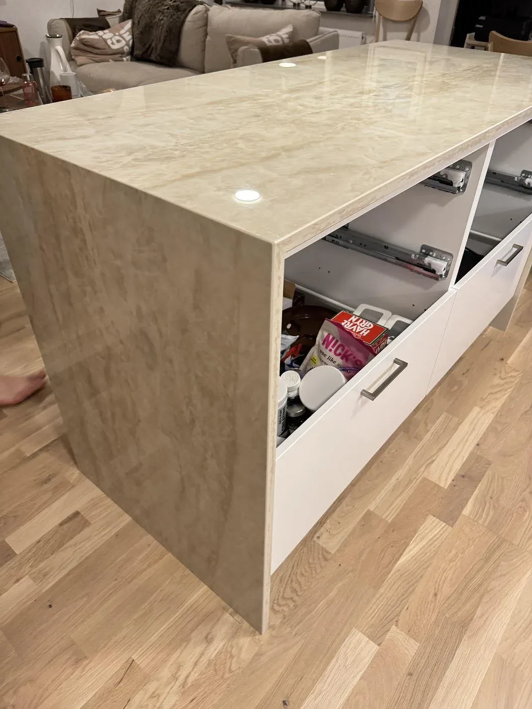 Sidovy av polerad Dekton Arga keramik på bänkskiva och gavelsida med ljusa skåp i ett kök i Lomma.