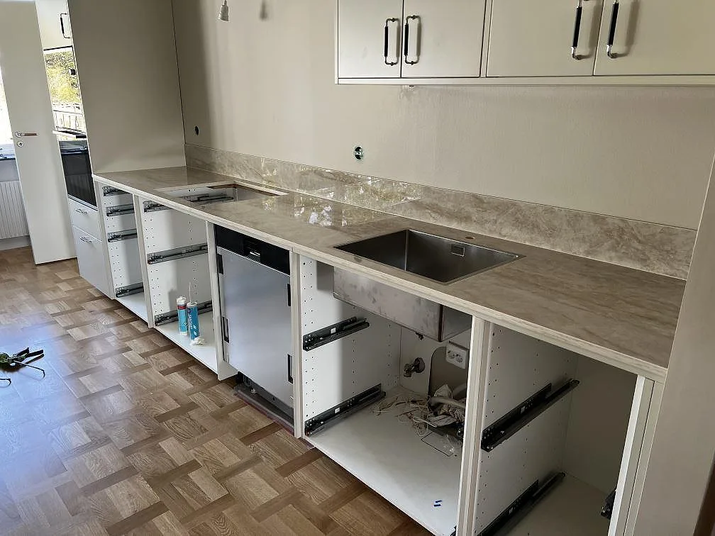 Köksbänkskiva i polerad Dekton Arga keramik med rostfri underlimmad diskho, hällöppning och matchande stänkskydd i Lund.
