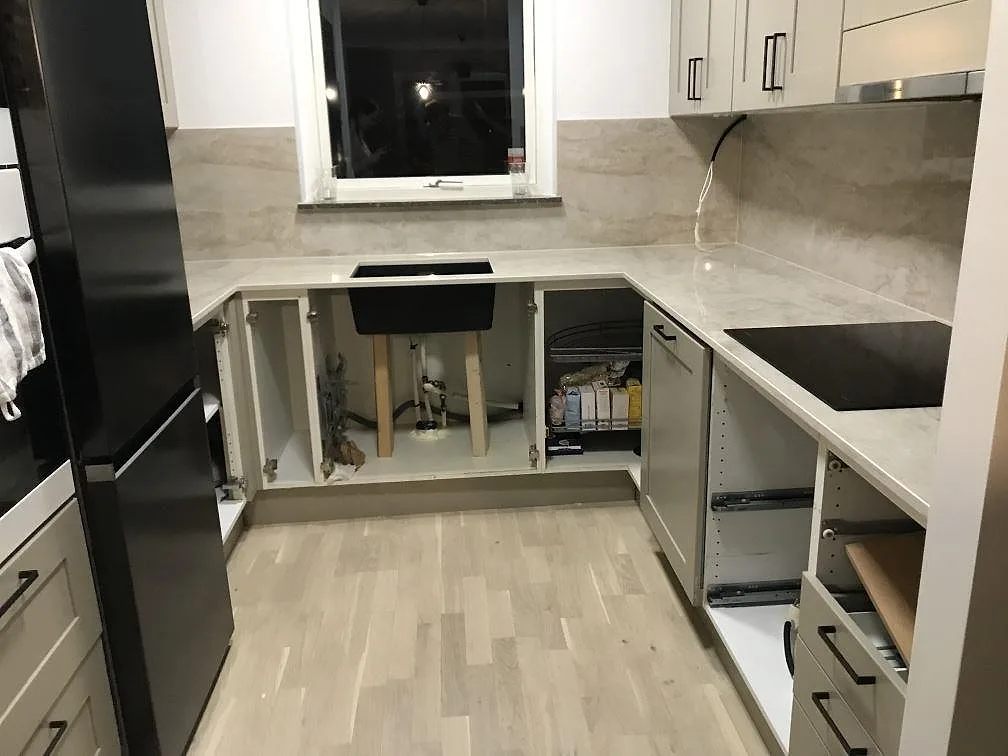 Köksbänkskiva i varmt cremebeige Dekton Arga, polerad, med matchande stänkskydd i ett U format kök under montering i Malmö.