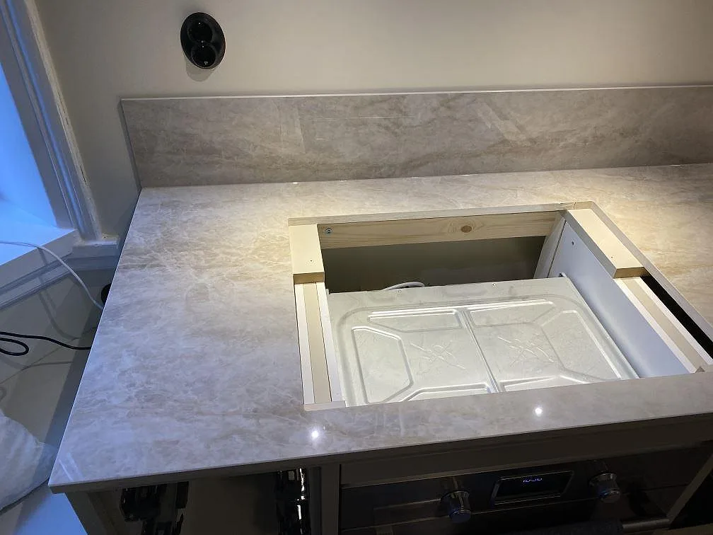 Dekton Arga bänkskiva i polerad keramik med urtag för häll och 8mm stänkskydd i ett kök i Malmö.