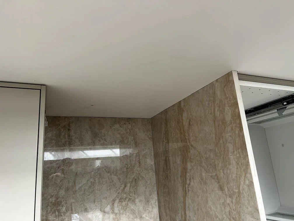Polerad väggbeklädnad i Dekton Arga med tydlig ådring i ett kök i Malmö.