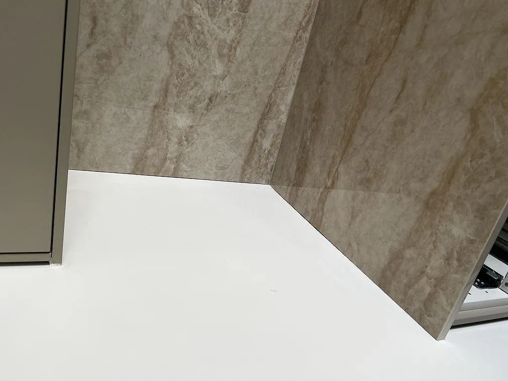 Detalj av polerad Dekton Arga väggbeklädnad med marmorlik ådring i ett kök i Malmö.