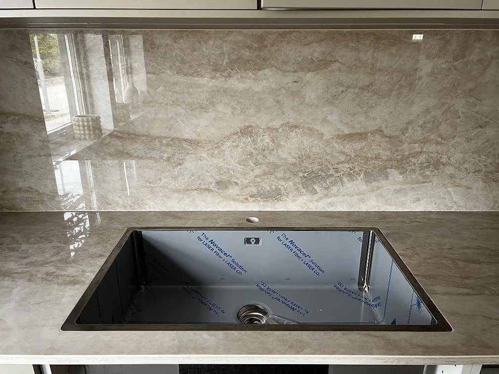 Svart underlimmad diskho i polerad Dekton Arga med matchande stänkskydd och fönsterreflexer i Malmö.