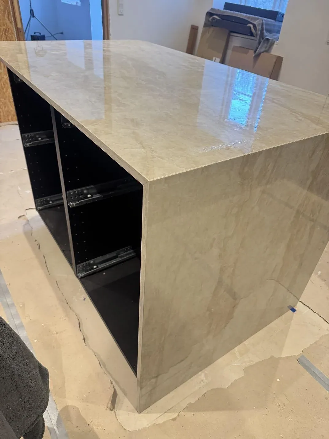 Köksö i polerad Dekton Arga med vattenfallskant sedd från sidan under montering i ett kök i Marstal på Ærø.