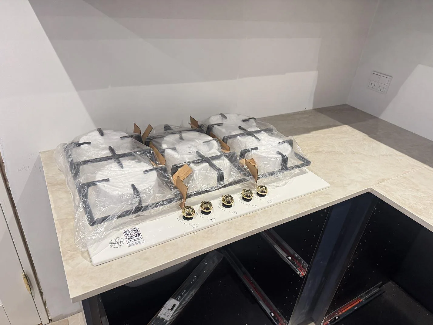 Köksbänkskiva i Dekton Arga med femlågig gashäll och mässingsvred på ett L-format bänkparti i ett kök i Marstal på Ærø.