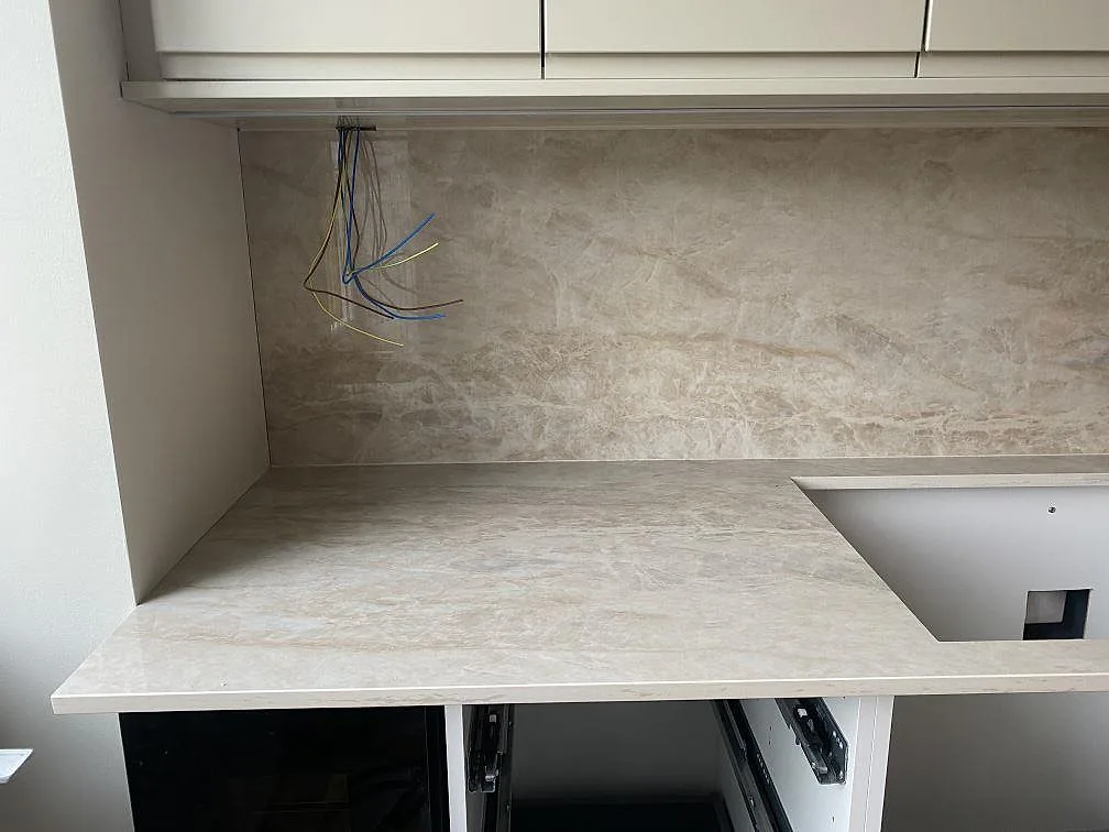 Sidovy av polerad Dekton Arga keramik med köksbänk, stänkskydd och synlig ådring under montering i Mölndal.