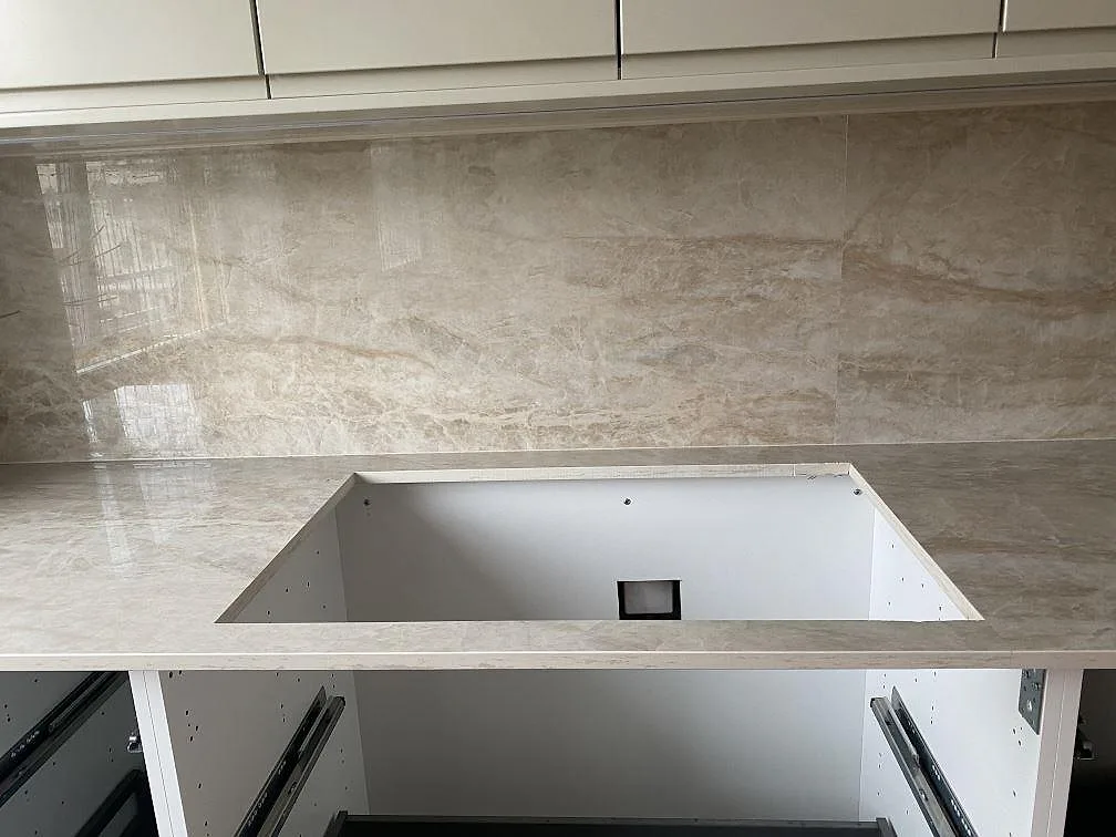Underlimmad diskho urtagen i polerad Dekton Arga köksbänkskiva med matchande stänkskydd i ett kök i Mölndal.