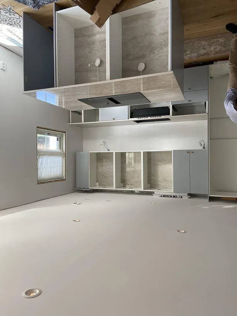 Lång köksbänkskiva i Dekton Arga med diskret grå ådring under montering i ett kök i Öjersjö.