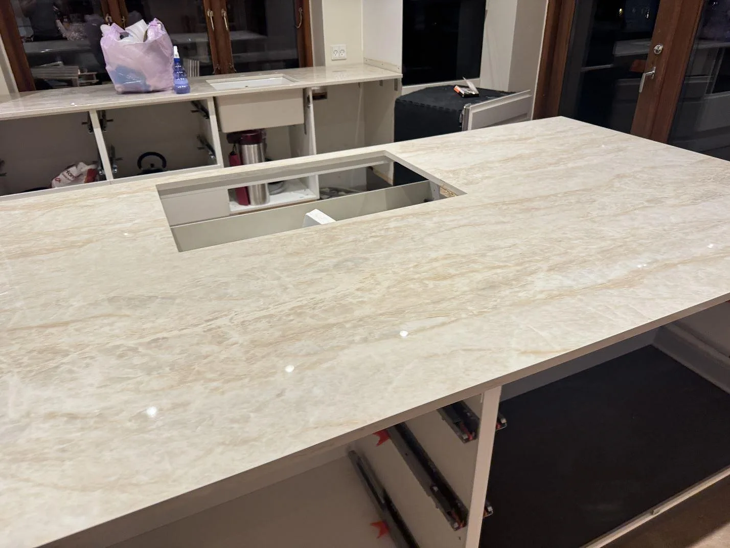 Närbild på polerad Dekton Arga som keramisk köksbänkskiva med ljus ådring och rektangulär urtagning i Roskilde.