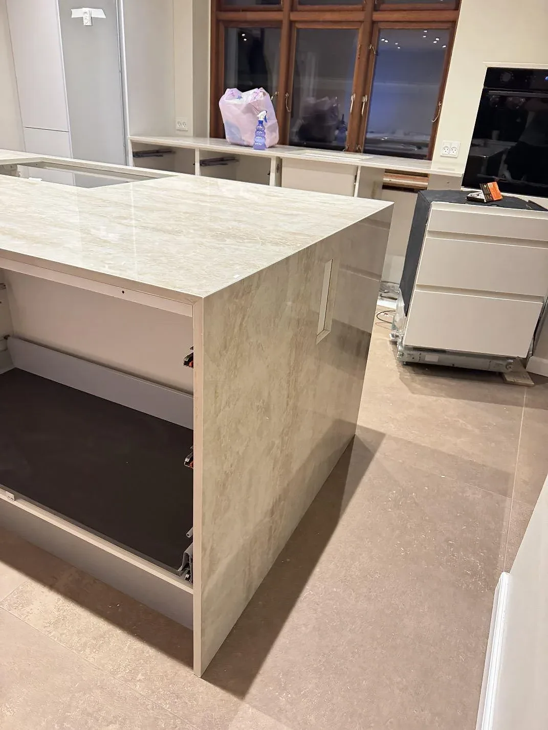 Polerad Dekton Arga på köksö med öppna stommar och synlig sidobeklädnad under montering i Roskilde.