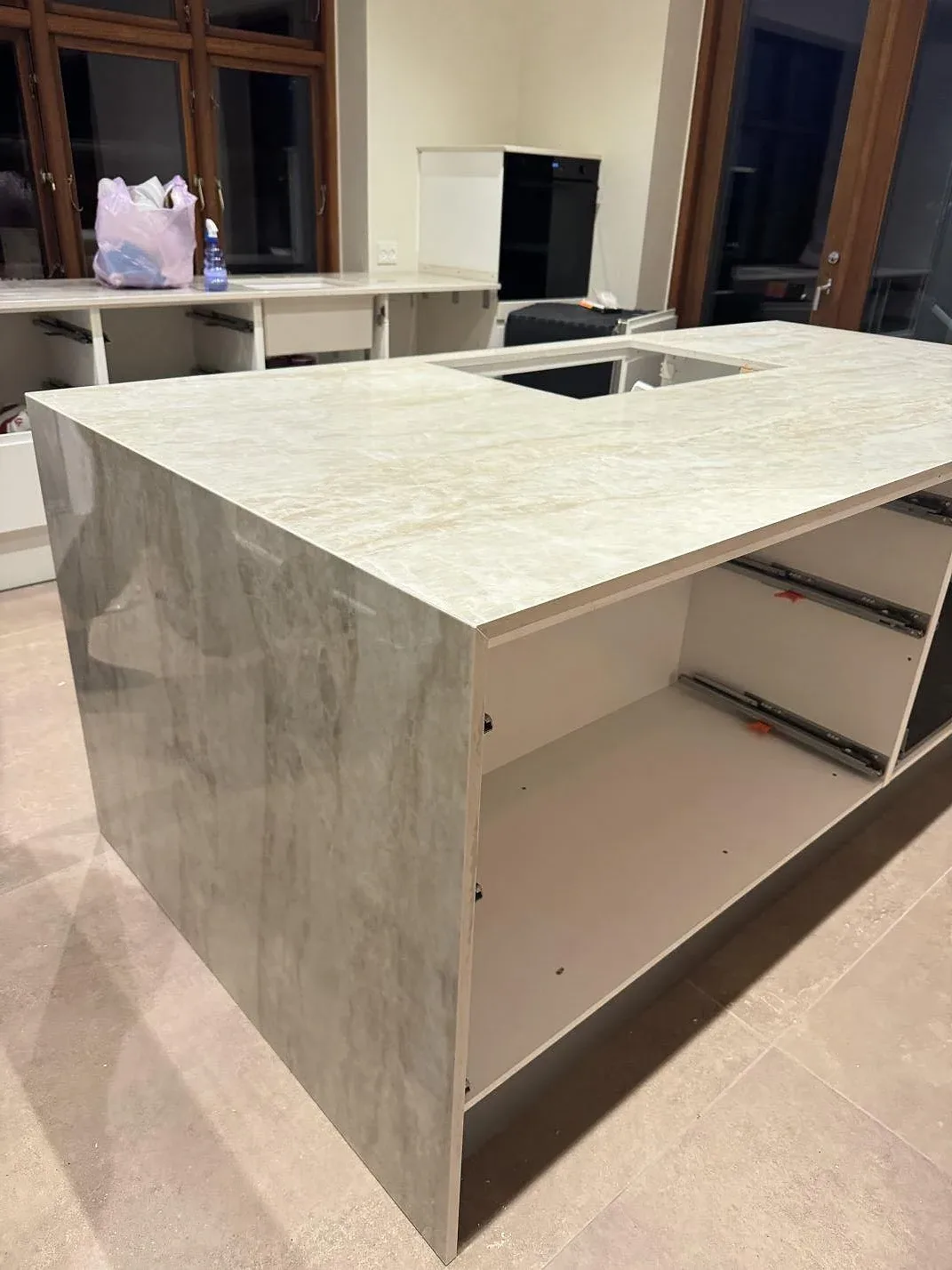 Sidovy av monterad köksö med polerad Dekton Arga som topp och sidobeklädnad i ett kök i Roskilde.