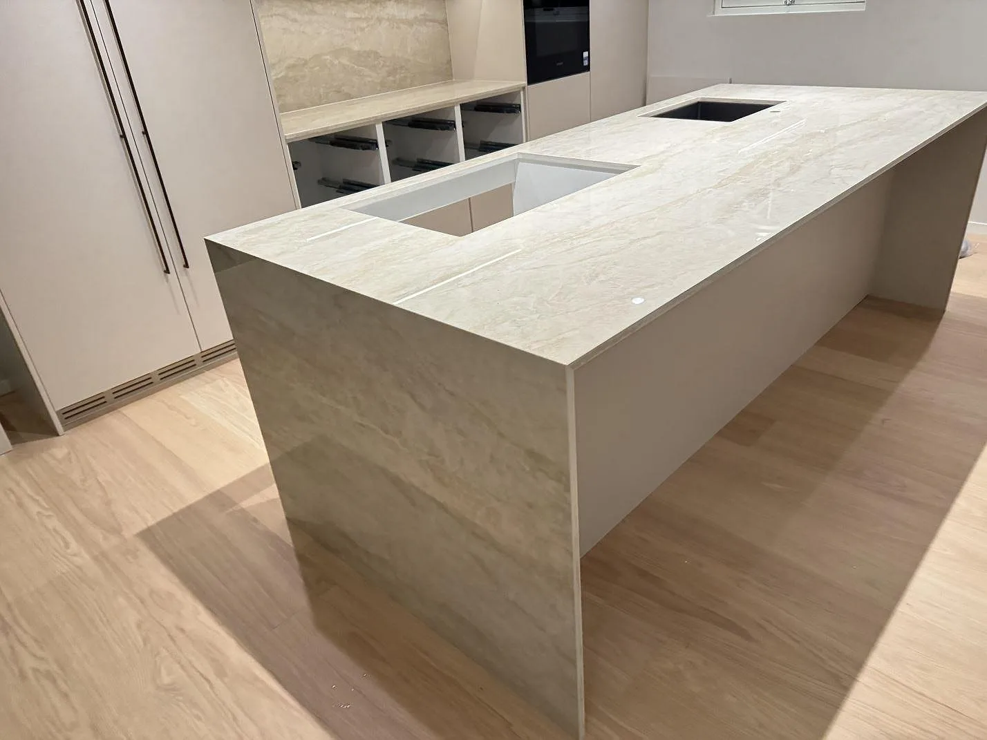 Köksö och bänkskiva i polerad Dekton Arga keramik med två förberedda urtagningar och vattenfallsida i Sandered.
