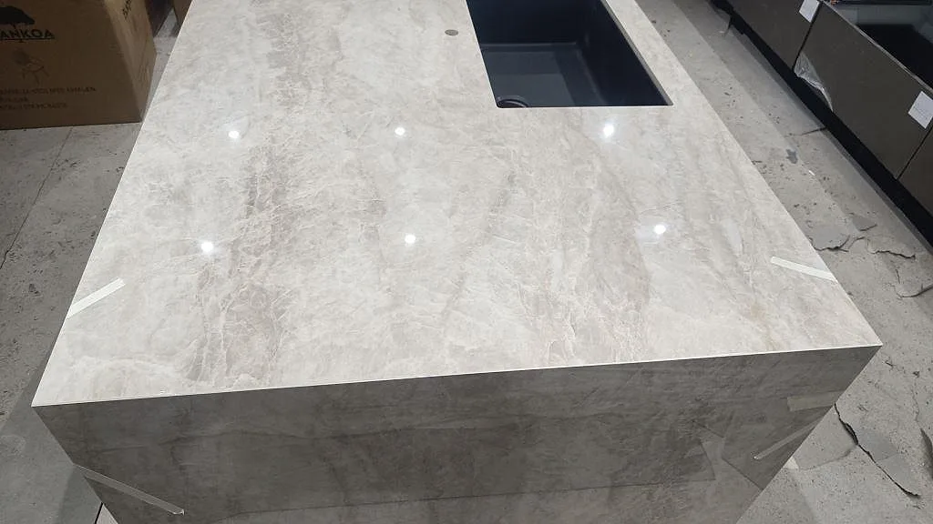 Polerad Dekton Arga som köksö med underlimmad diskho och blank marmorinspirerad ådring i ett kök i Sengeløse.