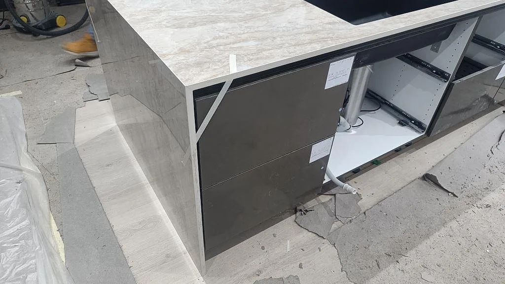 Detalj av Dekton Arga som köksö med underlimmad diskho, neddragen gavel och öppna köksstommar i Sengeløse.
