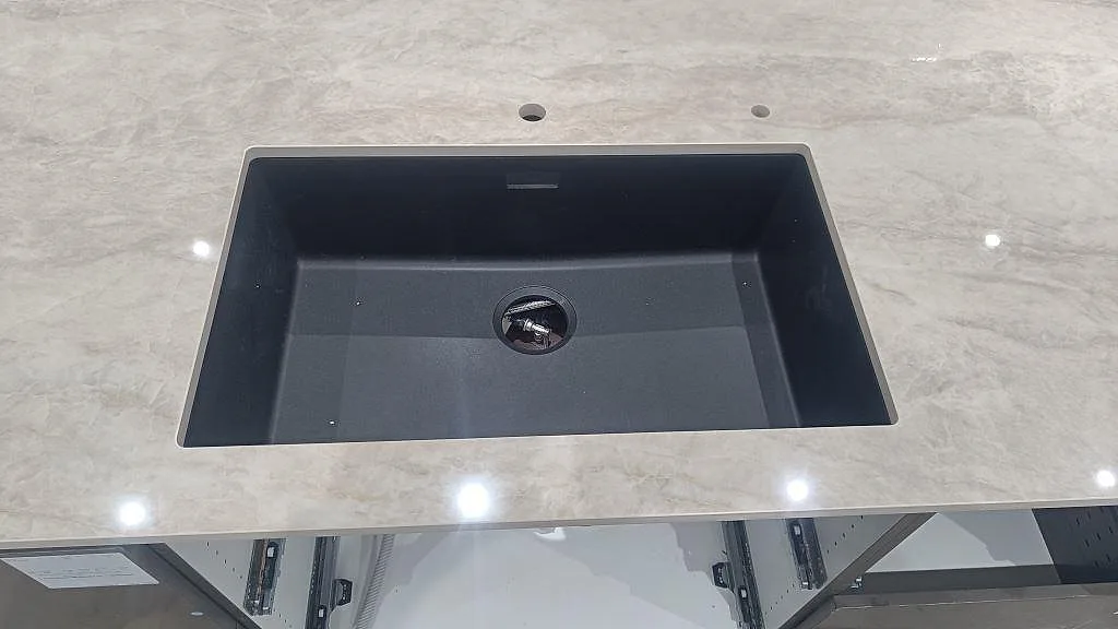 Närbild på underlimmad diskho i en polerad köksbänkskiva av Dekton Arga i Sengeløse.