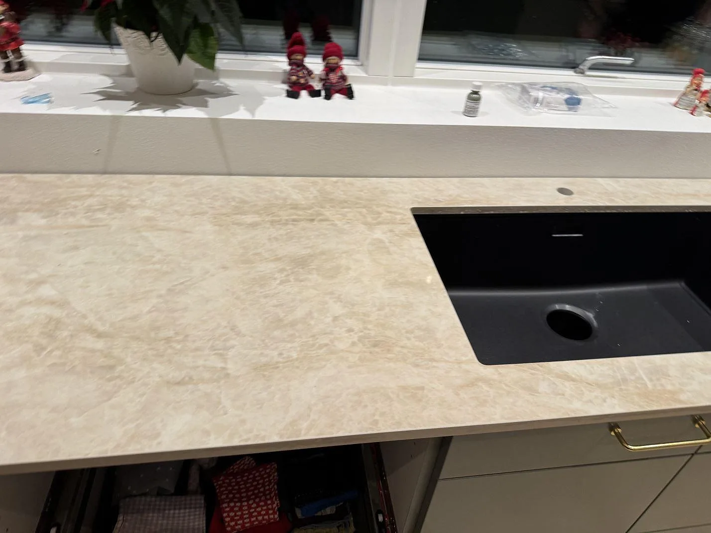 Köksbänkskiva i Dekton Arga med en svart underlimmad kompositdiskho och fönster bakom, polerad keramik i ett kök i Skovlunde.