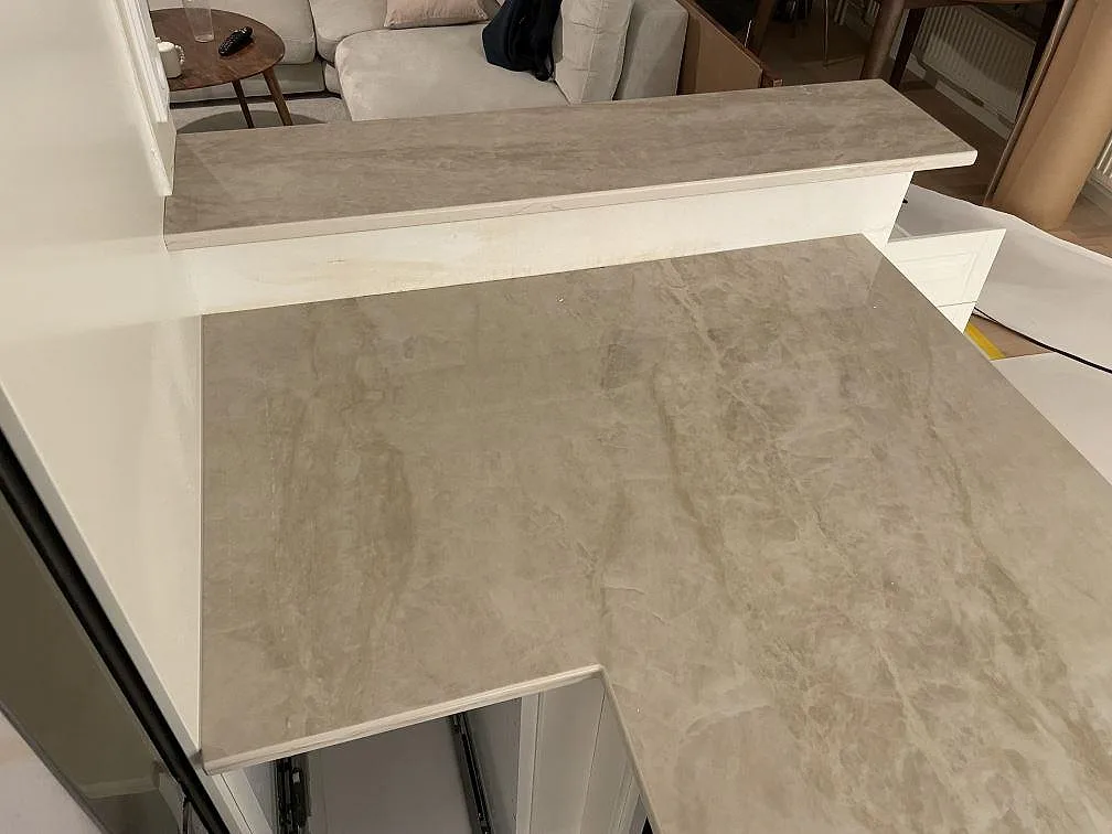 Bänkskiva i Dekton Arga sedd uppifrån, polerad yta med mjuk grågul ådring i ett kök i Solna.