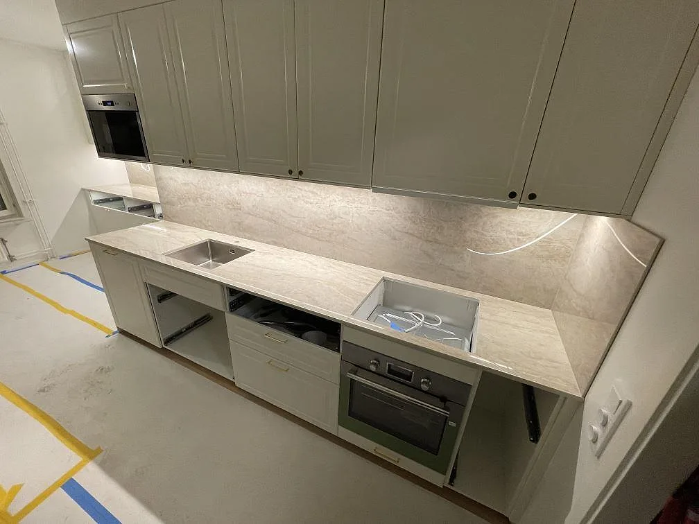 Köksbänkskiva i Dekton Arga med underlimmad rostfri diskho och stänkskydd längs väggraden i ett kök i Solna.