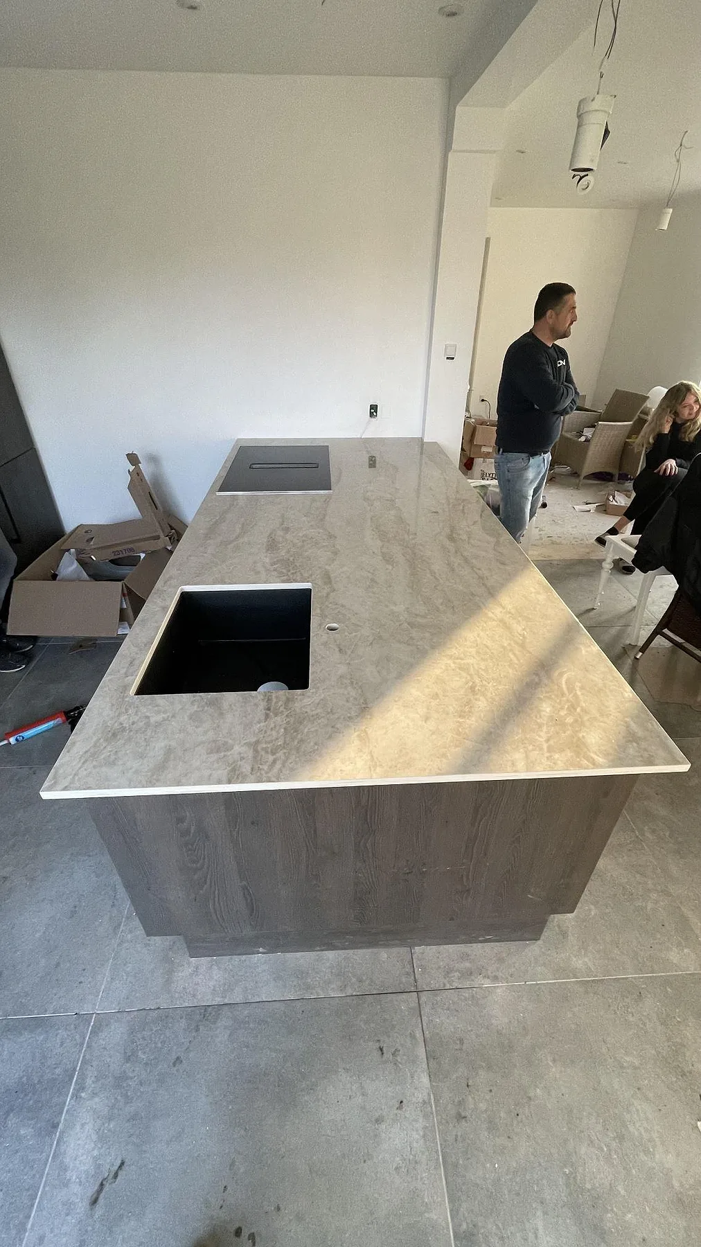 Köksö med köksbänkskiva i Dekton Arga, polerad keramik i varm gräddvit ton med grå ådring, med infälld induktionshäll och underlimmad diskho i ett kök i Solrød.