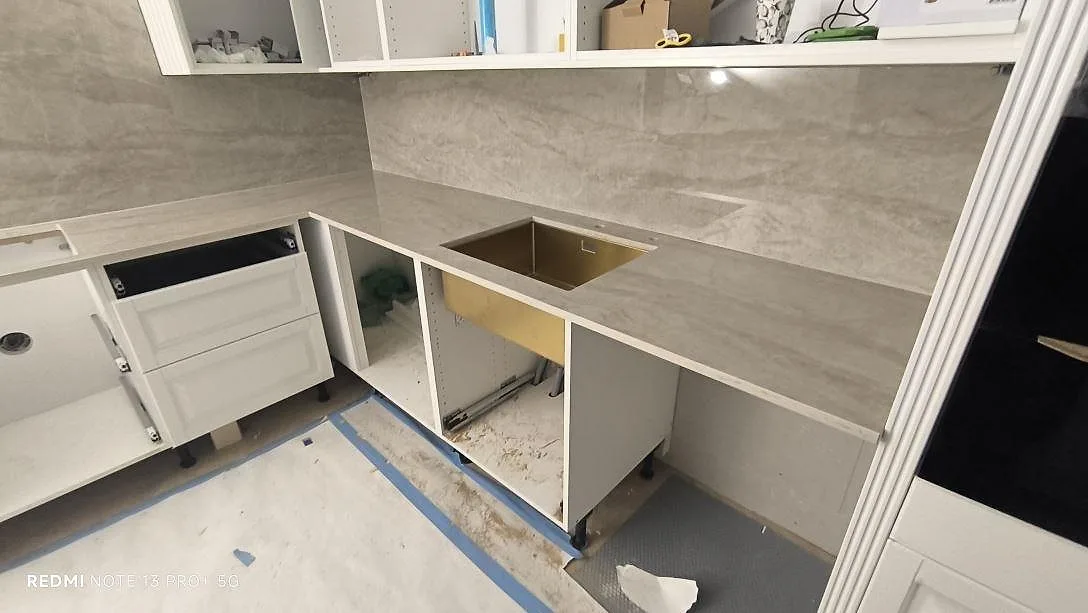 Polerad köksbänkskiva i Dekton Arga keramik med synligt urtag och 8 mm väggbeklädnad bakom bänken i Spånga.