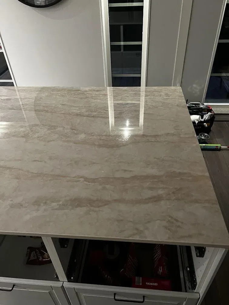 Närbild på polerad Dekton Arga keramik på halvö med taupefärgad ådring och blank yta i Stenkullen.