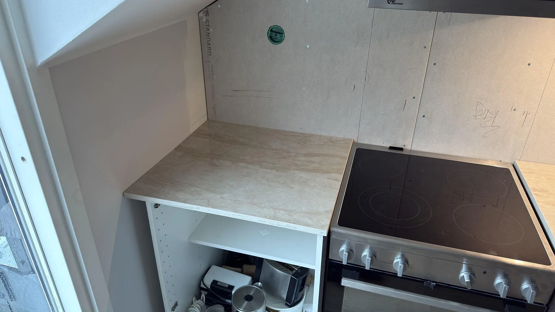 Hörna av polerad Dekton Arga köksbänkskiva i keramik vid fönster, fotograferad under montering i ett kök i Stockholm.