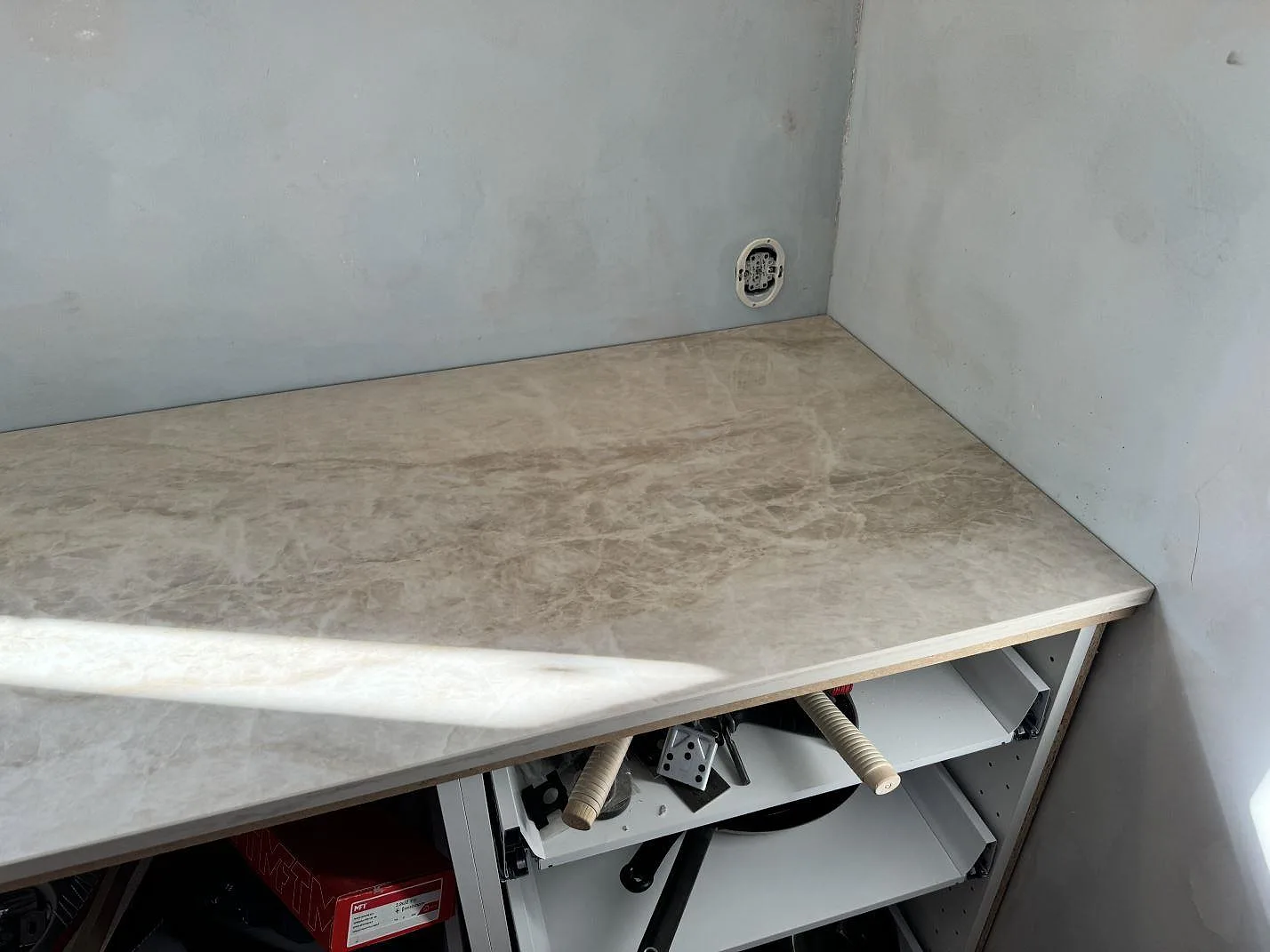 Hörn på köksbänkskiva i polerad Dekton Arga, 20 mm, med ljus ådring och öppna stommar i Svedala.