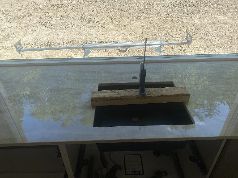 Svart underlimmad diskho i polerad Dekton Arga, med blank keramikyta och fältvy genom fönstret i Uddevalla.