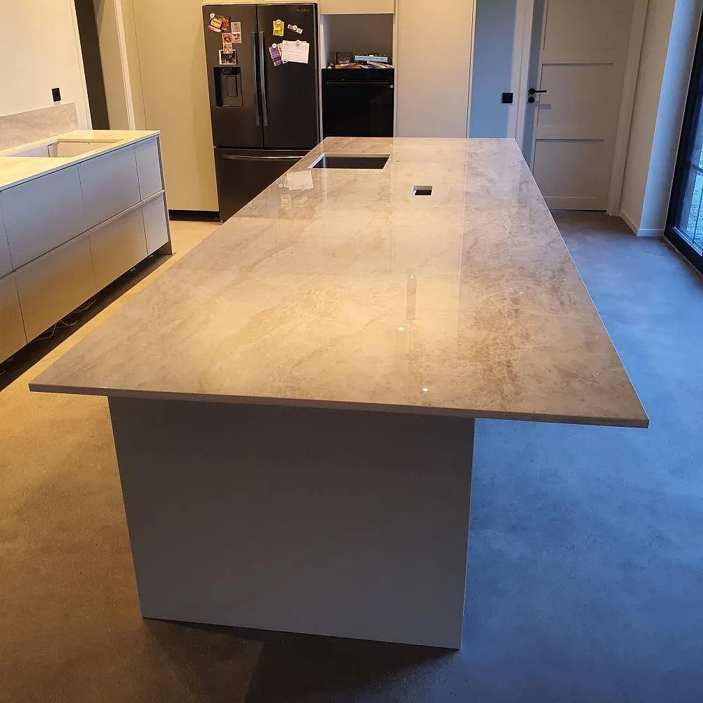 Närbild på polerad Dekton Arga keramik på köksö med synlig ådring, diskho och hällurtag i Uppsala.
