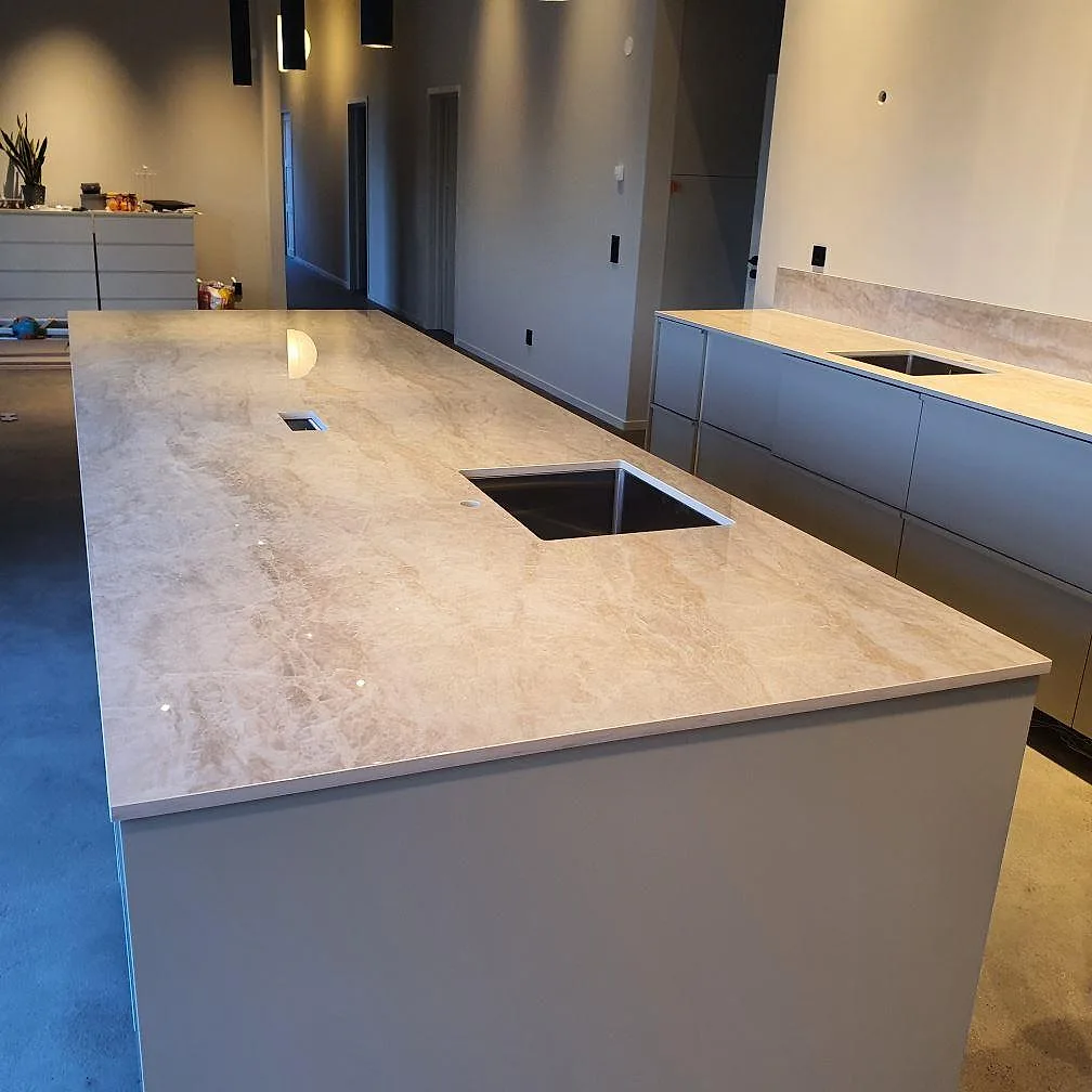 Polerad Dekton Arga keramik som köksbänkskiva på köksö med underlimmad rostfri diskho och låg stänkkant i Uppsala.
