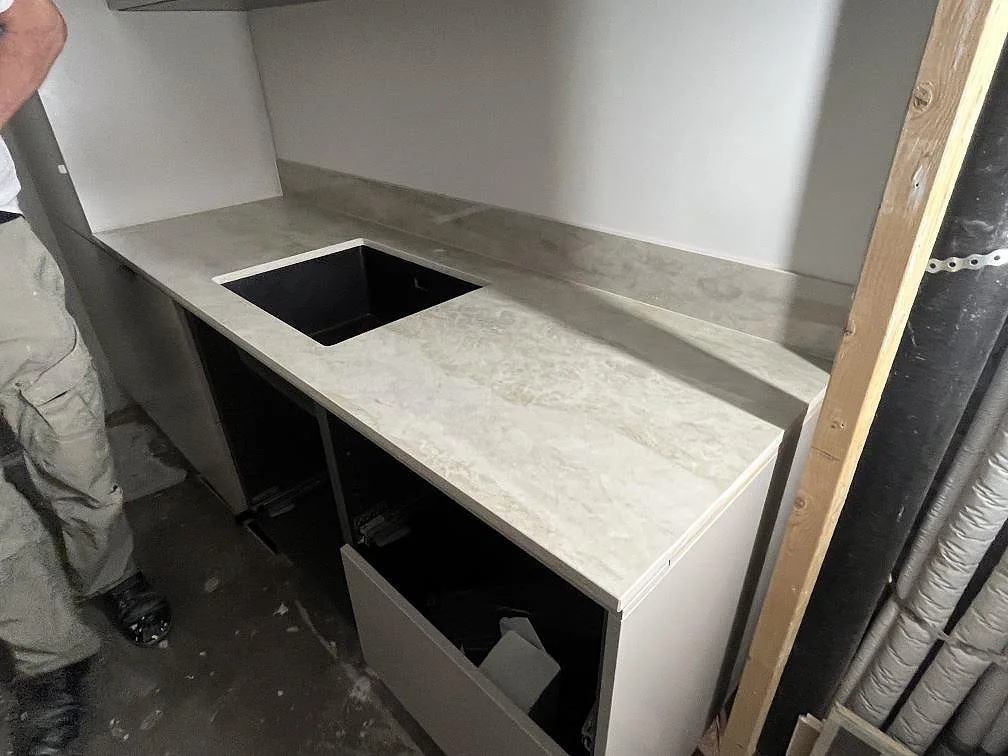 Polerad Dekton Arga som köksbänkskiva med diskhoöppning och 8 mm stänkskydd under montering i Uppsala.