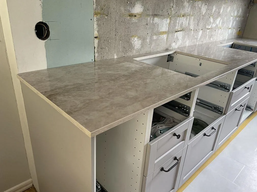 L-formad köksbänkskiva i polerad Dekton Arga med hällutskärning och underlimmad diskho i Västra Frölunda.