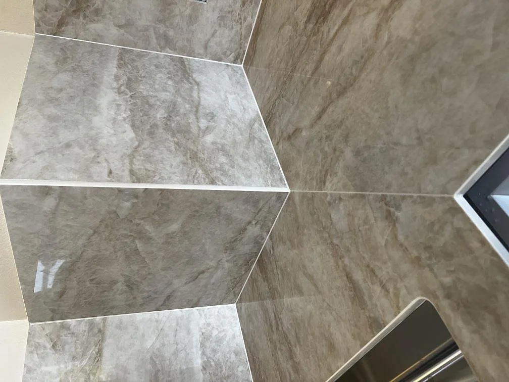 Närbild på polerad Dekton Arga bänkskiva som visar den marmorlika ådringen och underlimmad diskho i ett kök i Valby.